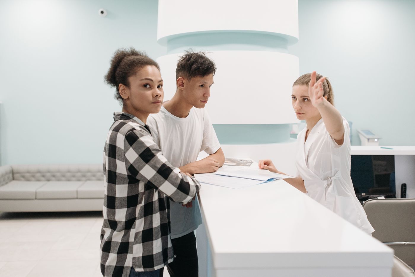 Clinic reception desk with staff assisting visitors